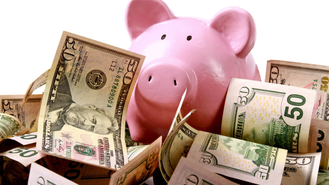 A pink piggy bunk surrounded by $50 notes.